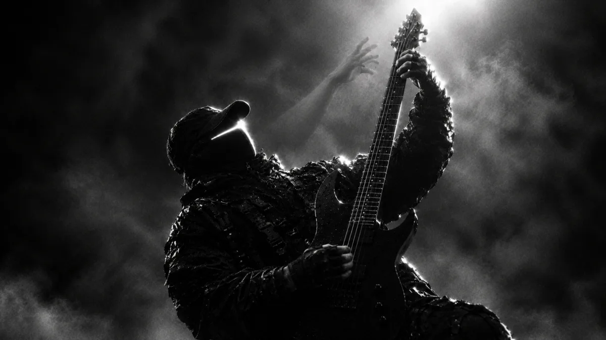 ③ Mid-solo, a translucent hand behind him fretting the same note